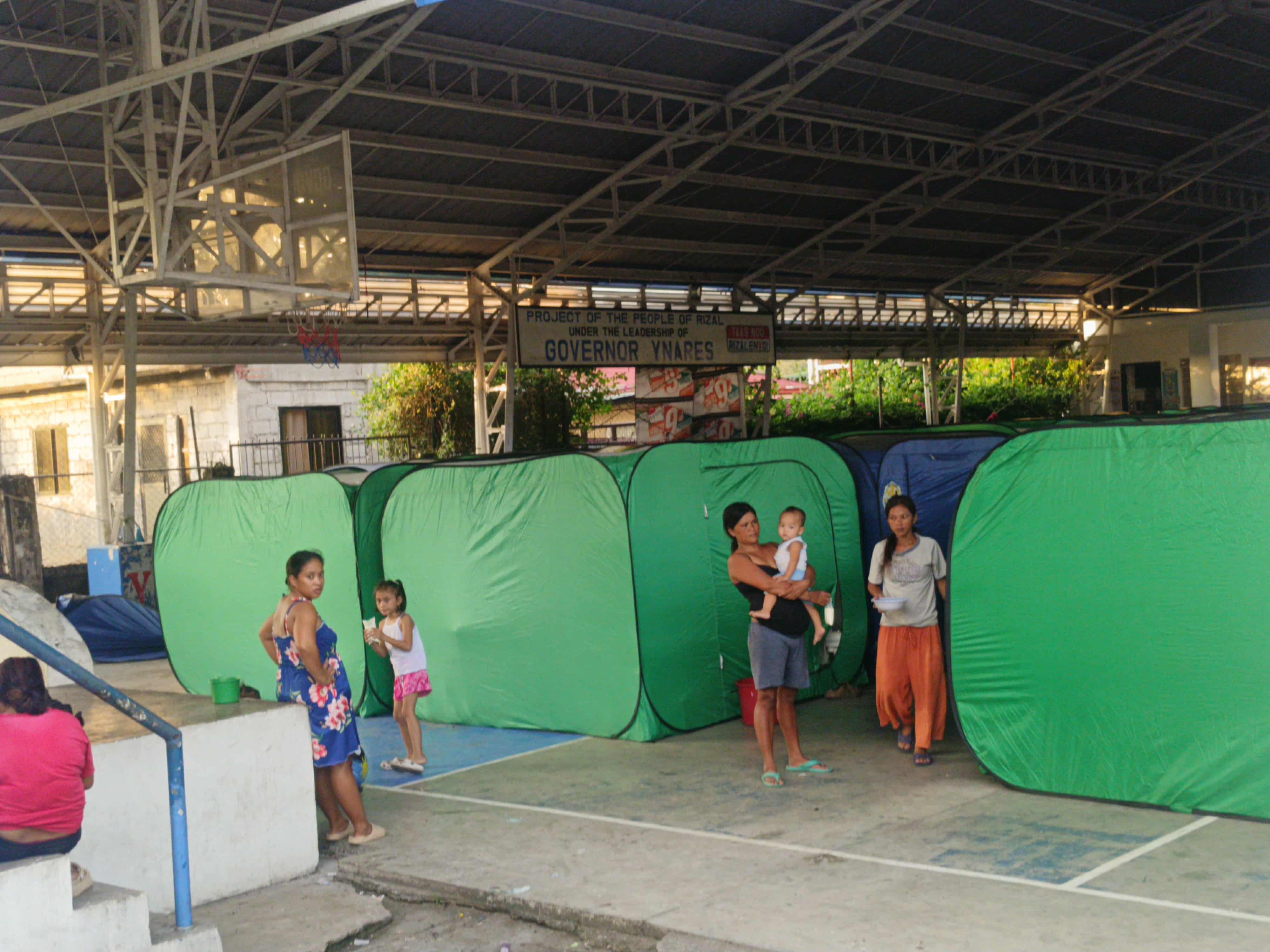 Mga pamilya sa loob ng green tents sa evacuation center